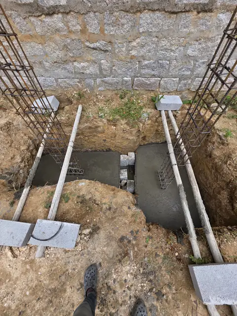 Column reinforcement cages beside stone wall - Mr. Santosh project, Andrahalli