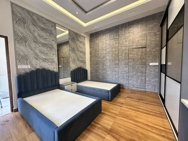 Two beds against stone-textured feature wall - Mr. Umesh project, Bangalore