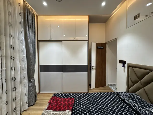 Bedroom wardrobe run beside curtained window - Ms. Rashmi project, Bangalore